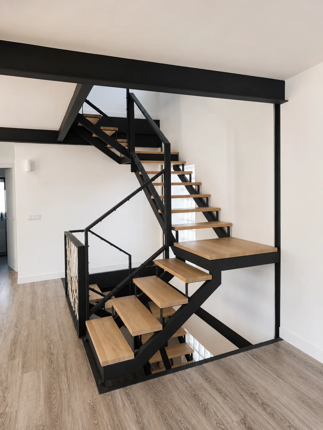 Escalera de estructura metálica vista y peldaños de madera sin tabica